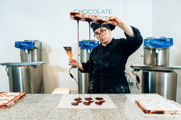 istock female chocolate master chef in black uniform working in confectionery 1589363756