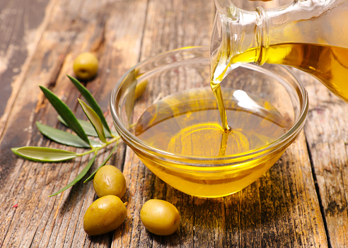 olive oil and leaf on wood background