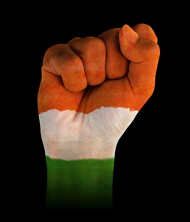 A vertical cutout of a fist of hand painted in three vibrant colored bands in orange, white and green. . The image denotes confidence, strength and determination.There is no text and Copy space for text. These colors are in the flag of India, Niger and also of Ireland and Côte d'Ivoire (Ivory Coast) country. Can be used for national festivals, events, national teams related backdrops of these countries like Republic Day, Independence Day celebrations.