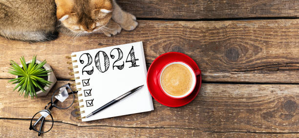 istock New year resolutions 2024 on desk. 2024 resolutions list with notebook, coffee cup, cute cat on table. Goals, resolutions, plan, cozy, hygge concept. New Year 2024 template 1589408787