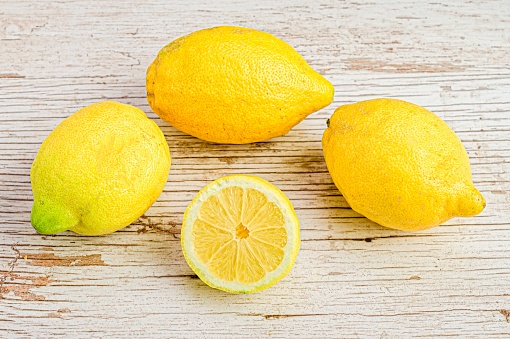 The fresh lemons on a white wooden background.