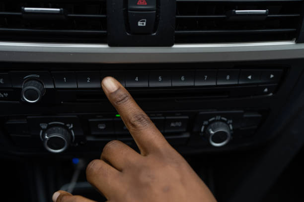 Unrecognizable black woman's hand relaxing changing radio stations in car.