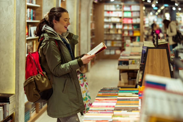 istock Young woman browsing bookshelves at bookstore 1589441015