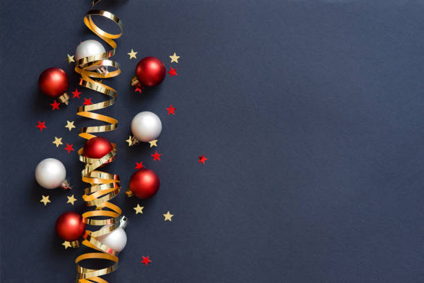 丸いボールのおもちゃ、クリスマスツリーの枝、金色の装飾リボン、キラキラの星、ボケライトを持つクリスマスカードのバナー。おめでとうございます。青の背景。 - star shape confetti red nobody ストックフォトと画像