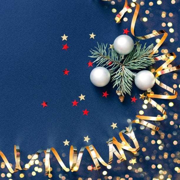 丸いボールのおもちゃ、クリスマスツリーの枝、金色の装飾リボン、キラキラの星、ボケライトを持つクリスマスカードのバナー。おめでとうございます。青の背景。正方形。 - star shape confetti red nobody ストックフォトと画像