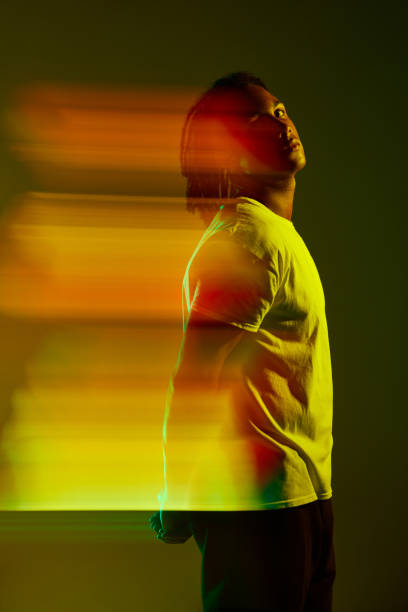 istock Portrait of handsome young guy posing against gradient green background in neon light. Mixed light effect. Digitalization 1589449066