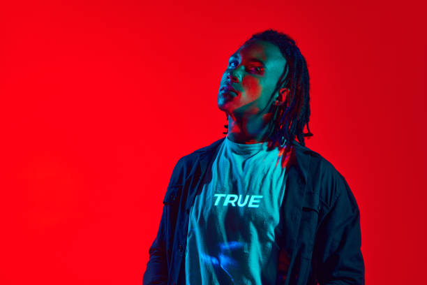 istock Truth. Handsome young man with neon filter reflection on body posing against red background in neon light 1589449604