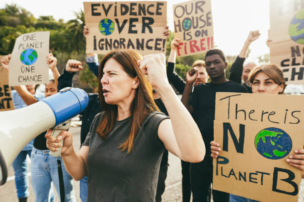 istock Multigenerational people protest against climate change - Crowd doing demonstration for stopping pollution - Green and environment concept - Focus on caucasian woman face 1589455972