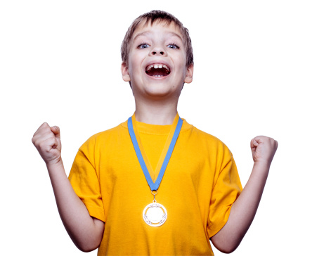 Happy expressive child in soccer or football uniform with medal isolated on white.