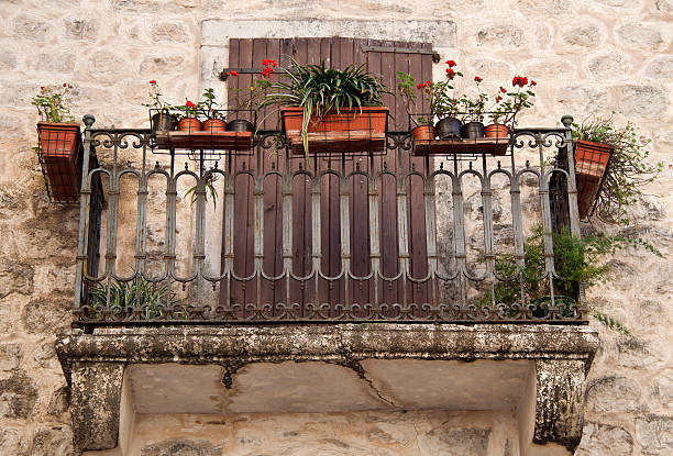 istock Mediterranean style balcony with red flowers in flowerpots 158946221