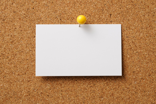 White Sticky Note With Contact Us And Red Push Pin On Yellow Background