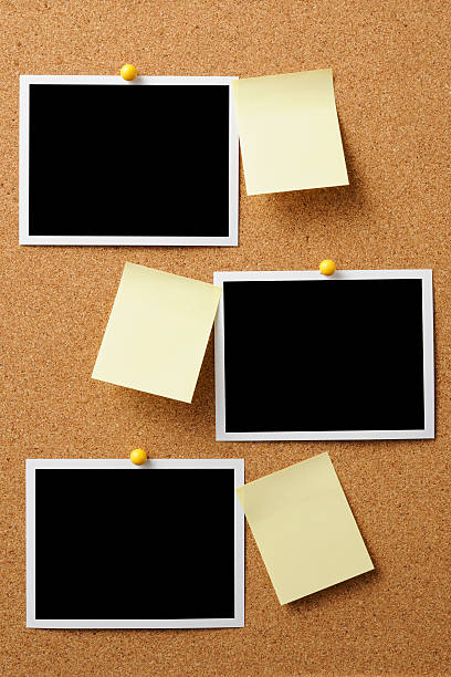 Blank Polaroid with yellow sticky note pinned on cork board Blank Polaroid with yellow sticky note pinned on cork board with copy space. bulletin board photos stock pictures, royalty-free photos & images