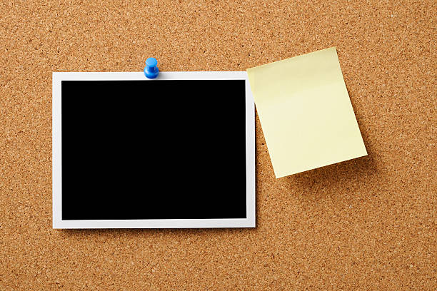 istock Blank Polaroid with yellow sticky note pinned on cork board 158947033