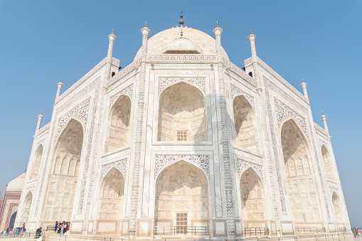 Awesome view of the Taj Mahal on blue sky background in Agra, India. The white marble mausoleum is a popular tourist attraction of South Asia.