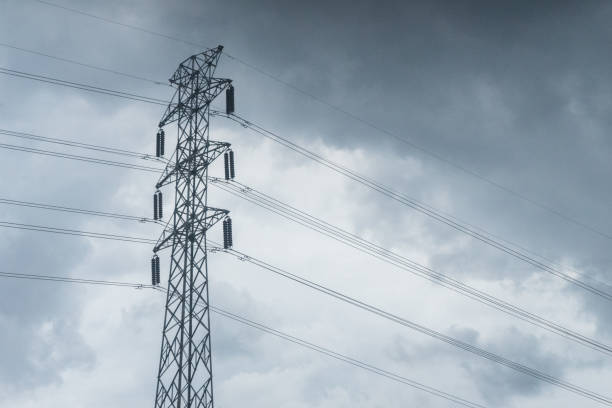 istock Power lines high voltage on dark cloudy sky electric wire 1589485146
