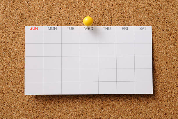 Yellow push pin on calendar 23th of the month with light and shadow