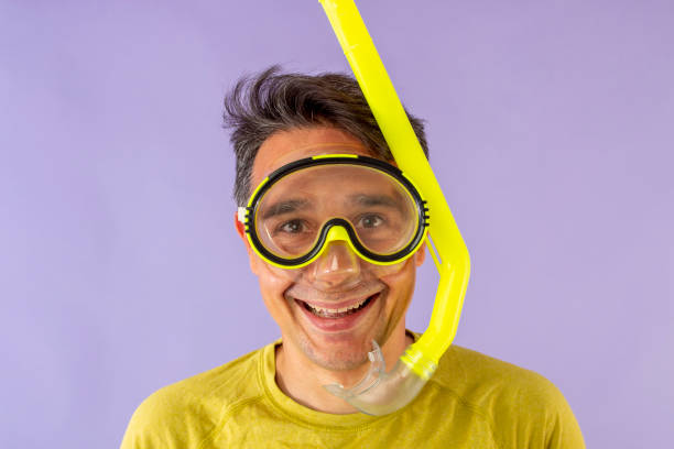 istock Man with goggles and snorkel dressed in brightly colored clothing 1589496837