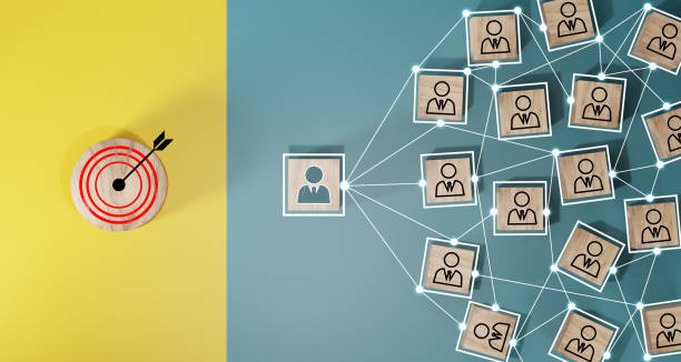 istock Red dartboard and black arrow connection linkage with human icon for customer focus target group and customer relation management concept. 1589498470
