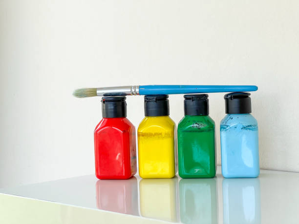 istock Paintbrush and four jars with bright colourful acrylic paint on a white background 1589501718