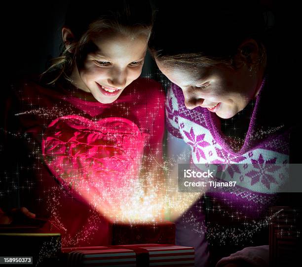 Two Cute Girls Looking Inside Of A Magical Present Stock Photo - Download Image Now - Backgrounds, Blond Hair, Box - Container