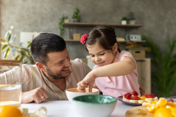 istock Father and daughter making a fruit salad at home 1589505001