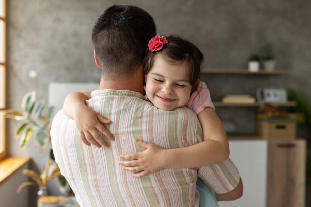 istock Father and daughter embracing at home 1589509889