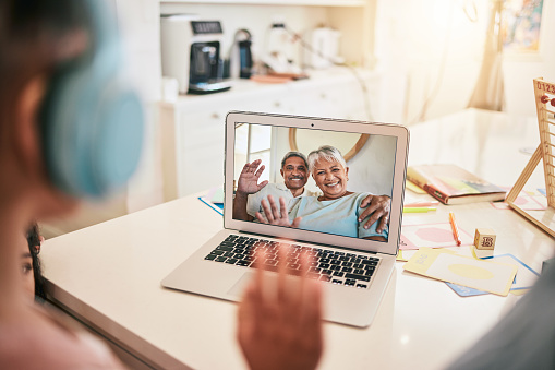 Video call, laptop screen and family wave hello for virtual communication of grandparents, mother and child at home. International, online discussion and happy, senior biracial people talking
