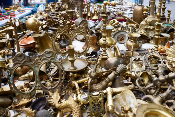 Scene at second hand and vintage  market stall with stacked household objects at Vintage market opposite to Chatuchak Weekend market in Bangkok. Small vintage and second hand market outside of a vintage market shopping mall. A senior man is passing in scene