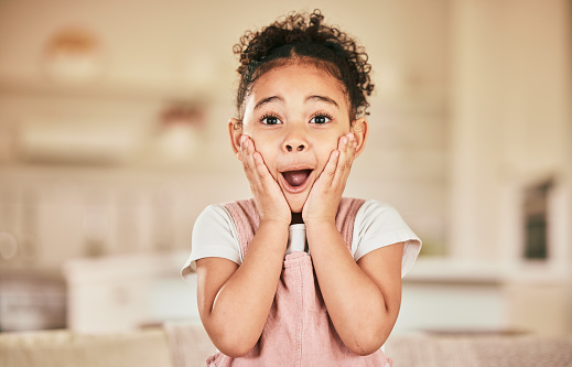 Wow portrait, reaction and a child in a house for news, announcement or excited. Shock, lounge and a young girl with a surprise expression a home living room for achievement or communication