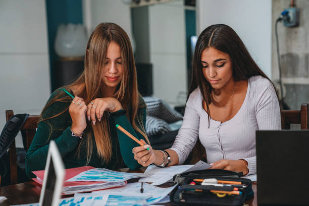 istock Friends are studying together with notebooks and laptops 1589525974