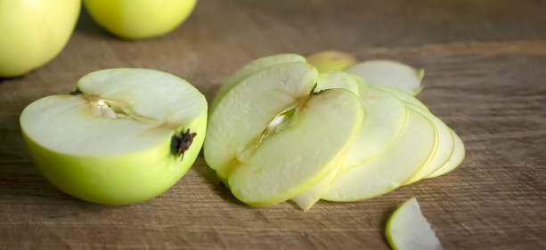 Sliced apple on a wooden board. A close shoot of an apple is rare. Cut apple in half.