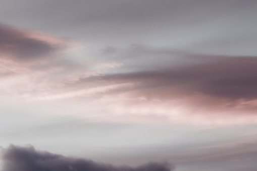 An abstract and soft look of clouds in the sky during sunset achieved by color dimming