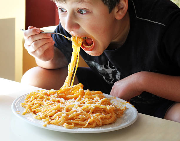 istock Young boy eating cheesy spaghetti 158953478