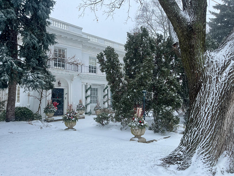 Winter snow-covered garden in front of a mansion. Toronto, Ontario, Canada. 2022-12-23