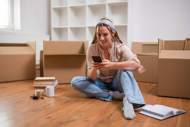 istock Happy ginger woman using phone in her new home 1589542227