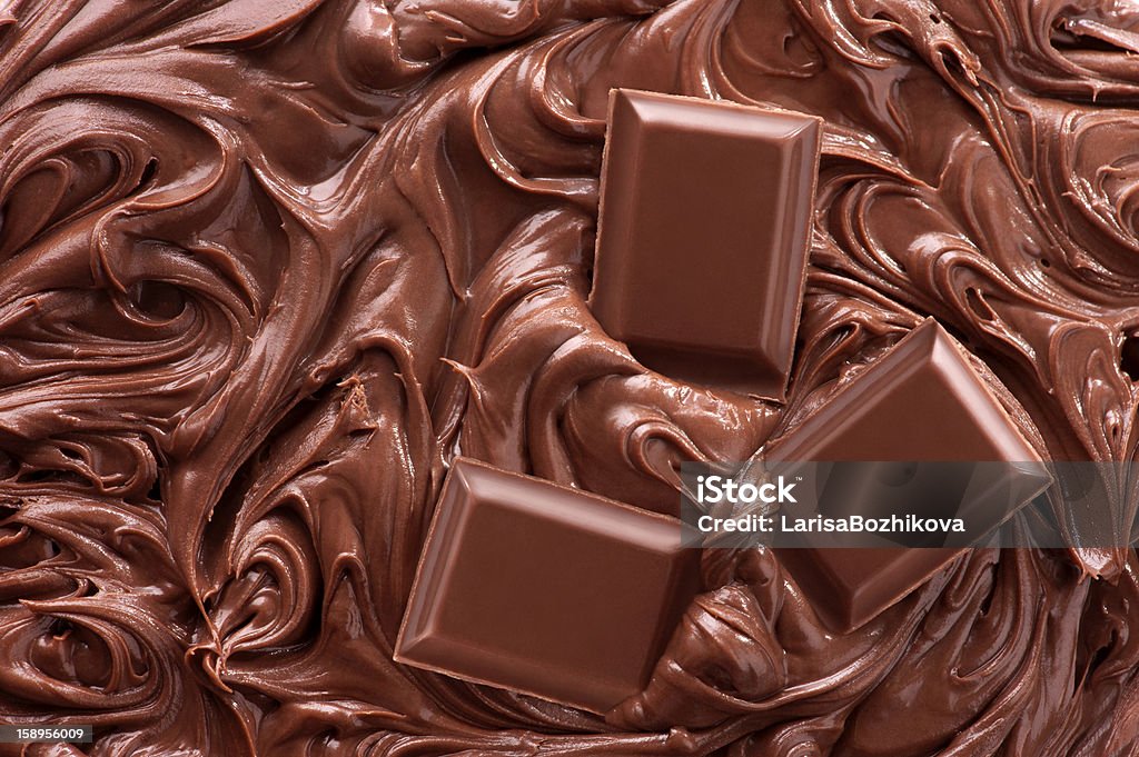 Melted Chocolate Background Close up of molten chocolate and pieces of chocolate bar Backgrounds Stock Photo