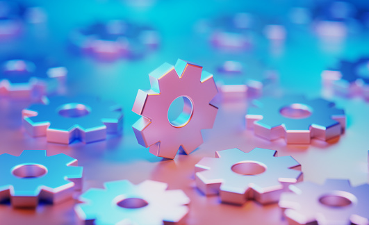 Metallic cog objects illuminated by blue and pink lights on blue and pink background. Horizontal composition with copy space.