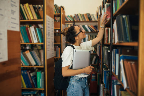 istock A student stuying and reading books in a public library. 1589602470