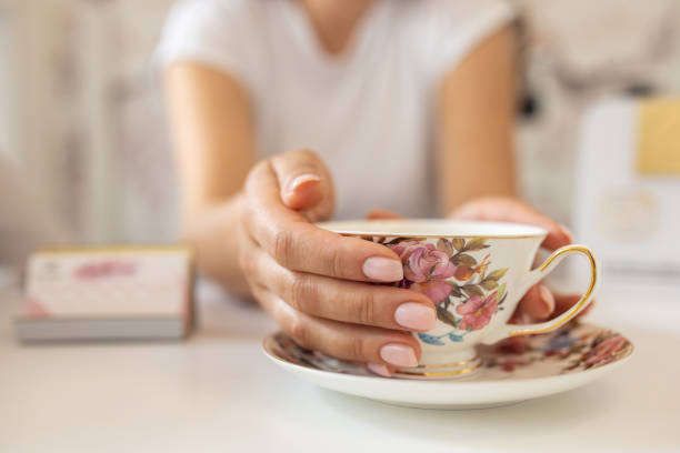 istock Woman holding a decorative tea cup 1589609444