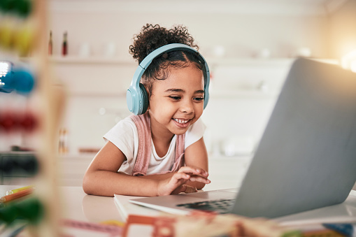 Laptop, home education and happy child elearning, kindergarten homework or remote school work. Knowledge website, e learning software and young kid streaming youth development lesson on headphones