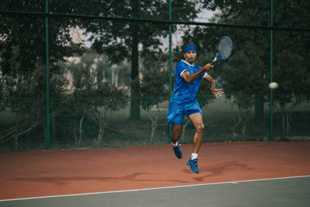 tennista professionista asiatico che gioca nel campo da tennis - tennis asian ethnicity male forehand foto e immagini stock