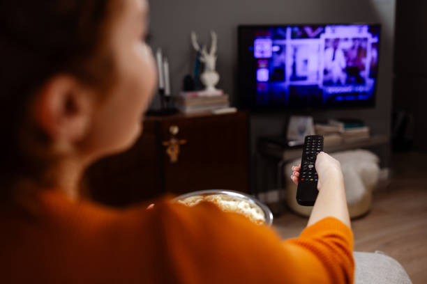 istock A young Caucasian woman switching TV channels 1589624520