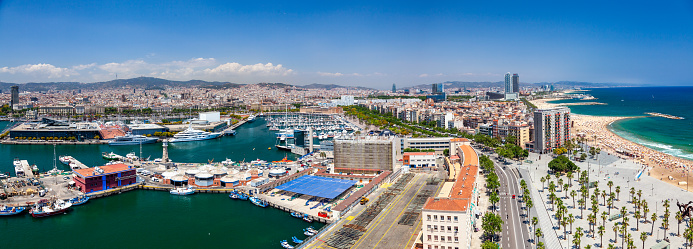A panoramic view from above of the city of Barcelona, Spain, showing its skyline, the Mediterranean Sea, and the beach. The image captures the contrast between the urban and natural landscapes, as well as the diversity of the city’s architecture and culture.