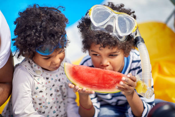 istock Refreshing Poolside Protein Snack: Little Brother and Sister Enjoying Watermelon 1589710102