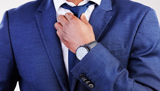 Business, man and fixing tie for fashion, professional clothes and corporate trader in studio. Closeup of male model, executive CEO and salesman in suit for style, pride and ready for job interview