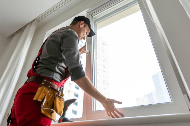 istock Workman in overalls installing or adjusting plastic windows in the living room at home 1589744828
