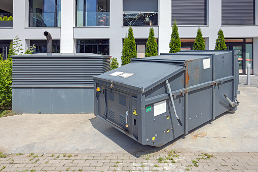 Mobile Press Container Compactor for Reducing Volume of Municipal and Industrial Waste Behind Building