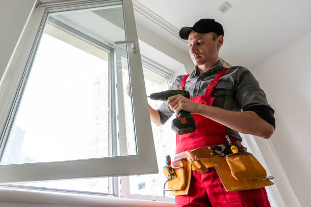 istock Professional installer of plastic windows poses in a working uniform, holds glasses with his hand. Specialist in the installation of plastic windows looks into the camera with a serious look 1589754593