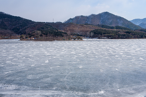 A hole in the ice on a river or lake in the cold winter for fishing is covered with ice.
