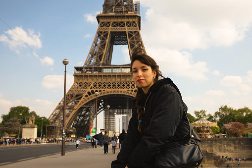 Portrait of woman in Paris in front of eiffel tower on the bridge